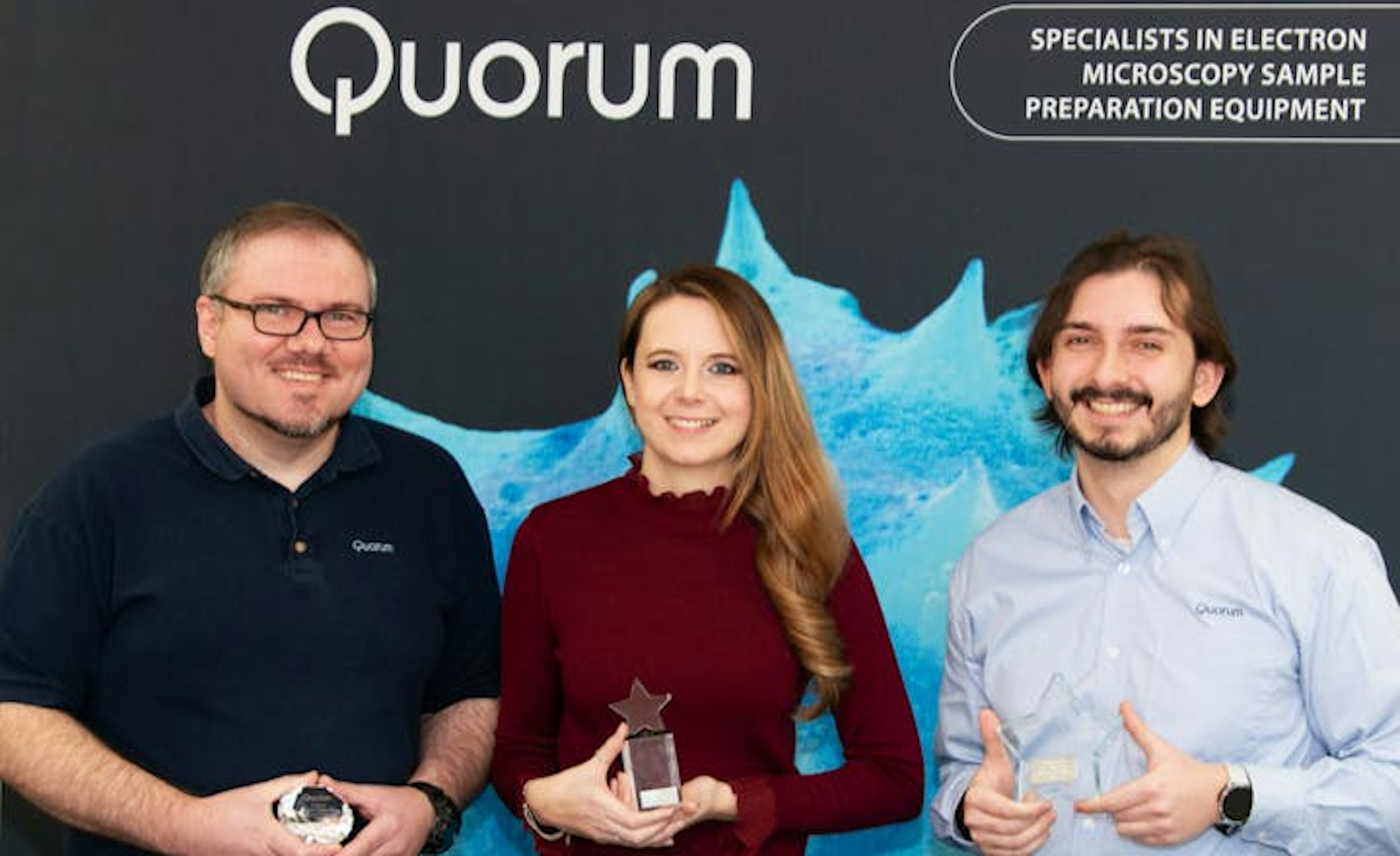 Three team members standing with an award.